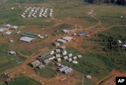 FILE - This Nov. 1978 file photo shows the Peoples Temple compound, led by Jim Jones, after bodies were removed, in Jonestown, Guyana.