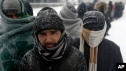 Migranti čekaju u redu za hranu u Beogradu