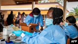 Seorang petugas kesehatan mempersiapkan sertifikat vaksin COVID-19 setelah memvaksinasi warga di wilayah Bimbo, dekat ibu kota Republik Afrika Tengah, Bangui, pada 15 November 2021. (Foto: AFP/Barbara Debout)