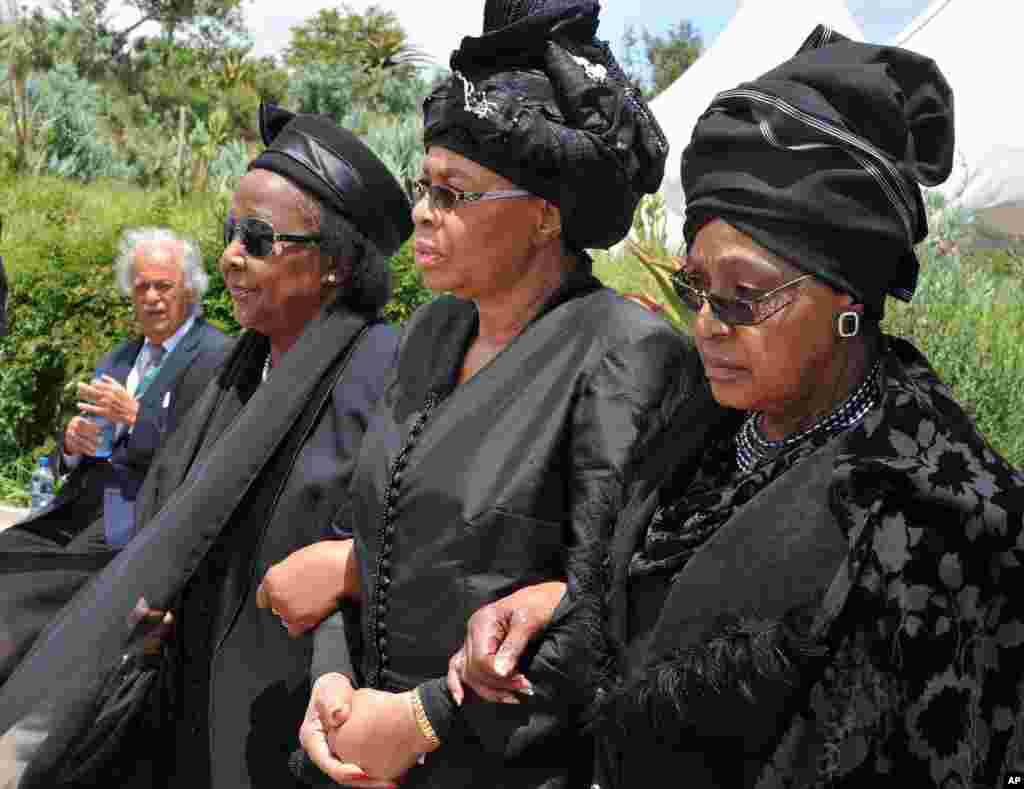 Winnie Madikizela-Mandela, kanan, mantan istri Nelson Mandela, dan janda Nelson Mandela Graca Machel, tengah, berjalan dari upacara pemakaman ke lokasi pemakaman mantan presiden Afrika Selatan Nelson Mandela di Qunu, Afrika Selatan, 15 Desember 2013.