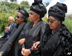 FILE - Winnie Madikizela-Mandela, right, Nelson Mandela's former wife, and Nelson Mandela’s widow Graca Machel, centre, walk from the funeral service to the burial site of former South African President Nelson Mandela in Qunu, South Africa, Sunday, Dec. 15, 2013.