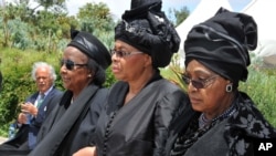 Winnie Madikizela-Mandela, right, Nelson Mandela's former wife, and Nelson Mandela’s widow Graca Machel, centre, walk from the funeral service to the burial site of former South African President Nelson Mandela in Qunu, South Africa, Sunday, Dec. 15, 201