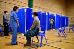 Medical staff prepares to administer the Pfizer-BioNTech COVID-19 vaccine at a vaccination center in Cardiff, Wales, Tuesday Dec. 8, 2020.