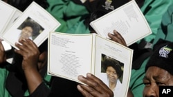 Mourners display the programs, as they gather for the funeral service of Albertina Sisulu, in Soweto, South Africa, June 11, 2011