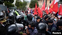 Agentes de policía montan guardia durante la marcha de sindicalistas ecuatorianos contra las reformas laborales propuestas por el presidente Guillermo Lasso en Quito, Ecuador, el 20 de octubre de 2021. 