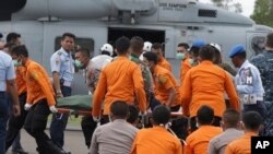 Tim SAR dan polisi Indonesia membawa jenasah korban AirAsia yang dikeluarkan dari helikopter Angkatan Laut USS Sampson di pelabuhan Pangkalan Bun (2/1/2015).