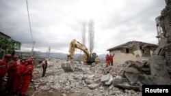 Personal de emergencia buscan entre escombros de edifices colapsados el 26 de noviembre de 2019 en Thumanae, Albania.
Emergency personnel stand on debris of collapsed and damaged buildings following Tuesday's powerful earthquake in Thumane, Albania, 