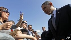 President Barack Obama greets supporters on the tarmac on his arrival at O'Hare International Airport in Chicago, Friday, March, 16, 2012.