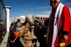 Pastor Sebastian Obermaier memberkati seekor anjing dengan air suci selama Hari Anjing, setelah merayakan Misa di El Alto, Bolivia, Sabtu, 16 Agustus 2014. (Foto: AP/Juan Karita)
