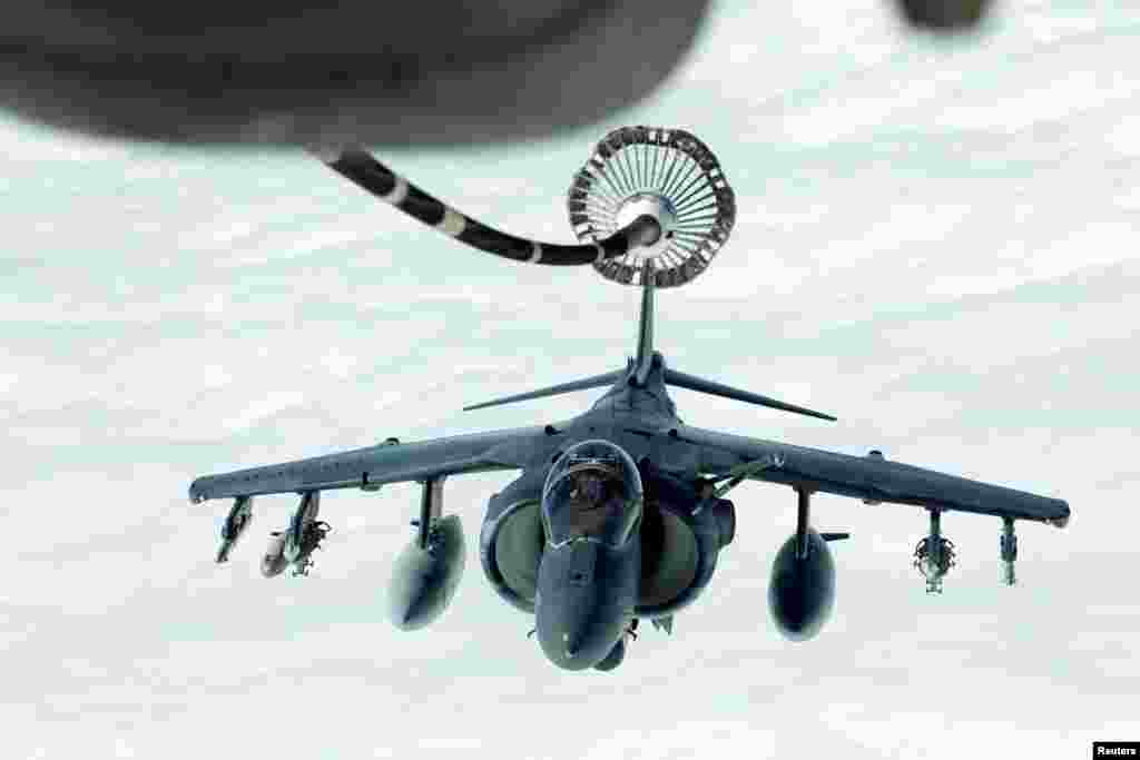 A U.S. Marines Harrier AV-8B makes its way to a fueling boom suspended from a U.S. Air Force KC-10 Extender during mid-air refueling support to Operation Inherent Resolve over Iraq and Syria air space.
