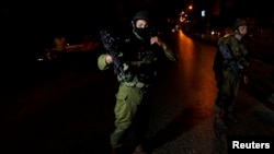 Israeli soldiers take part in an operation to locate three Israeli teens in the West Bank City of Hebron, June 20, 2014.