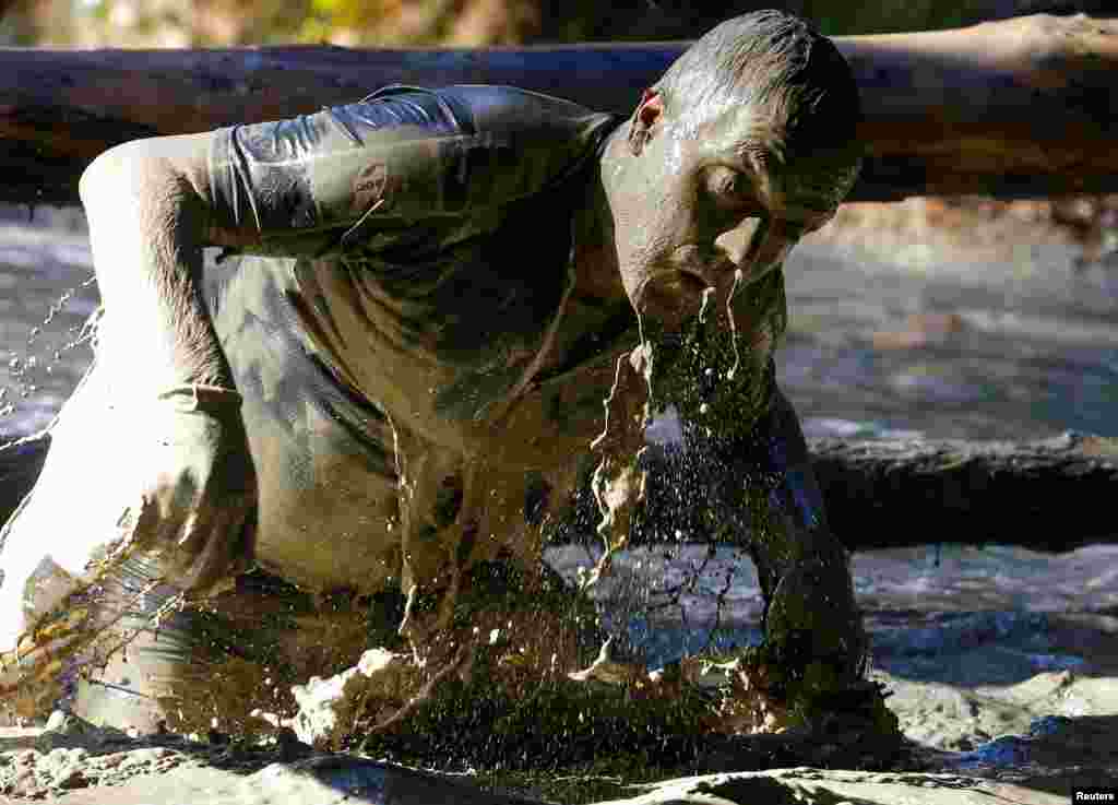 오스트리아 오베르트리스팅 인근에서 22일(현지시간) 열린 &#39;야생돼지 진흙탕 뒹굴기&#39; 장애물 경기대회 참가자가 물 웅덩이를 건너고 있다.