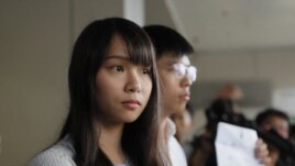 In this Friday, Aug. 30, 2019, photo, pro-democracy activists Joshua Wong, right, and Agnes Chow speak to media outside a district court in Hong Kong. (AP Photo/Kin Cheung)