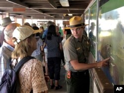 Tourists get directions from a park ranger on Sept. 22, 2018, the first day Hawaii Volcanoes National Park is reopened after volcanic activity forced the park to close for more than four months in Hawaii.