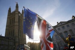 지난해 11월 영국 런던 의회의사당 앞에서 브렉시트에 반대하는 시위자가 유럽연합 깃발과 영국 국기를 흔들고 있다.