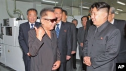 North Korean leader Kim Jong Il (front L) and his son Kim Jong-un (R) talk as they visit Mokran Video Company in Pyongyang, in this undated picture released September 11, 2011.