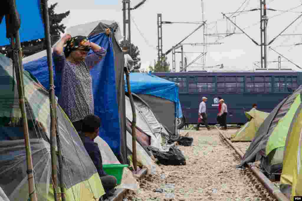 Many tents have been set up along the railway line, which used to pass into Macedonia. Police vans now block the way, April 23, 2016. (J. Owens/VOA)