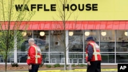 Para petugas gawat darurat berjalan di luar restoran Waffle House, 22 April 2018.