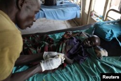 FILE - An UPDF medic takes care of a malnourished child with malaria in a hospital in Bor on March 15, 2014.