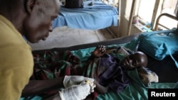 FILE - A medic takes care of a malnourished child with malaria in a hospital in Bor, South Sudan, March 15, 2014. 