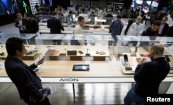 FILE - People look at ZTE Axon mobile phones during the Mobile World Congress in Barcelona, Spain, Feb. 25, 2016.