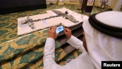 A Saudi man takes photos of Iran-aligned Houthi drones, brought down April 11, 2018, over Jizan and Abha, during a news conference in Khobar, Saudi Arabia, April 16, 2018. Saudi security forces shot down a recreational drone in the capital on Saturday, briefly sparking speculation of political unrest.