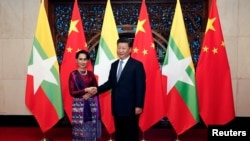 មេដឹកនាំ​រដ្ឋាភិបាល​ លោកស្រី​ Aung San Suu Kyi (រូបខាង​ឆ្វេង) និង​លោក​ប្រធានាធិបតី​ចិន Xi Jinping ស្វាគមន៍​ក្រុមអ្នក​យកព័ត៌​មាន​មុនពេល​កិច្ចប្រជុំ​នៅរដ្ឋធានី​ ប៉េកាំង​ ថ្ងៃទី១៩​ ខែសីហា​ ឆ្នាំ២០១៦។ 