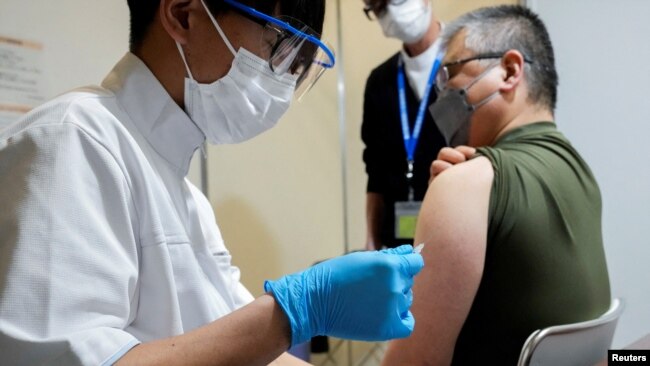 Seorang pria menerima suntikan booster vaksin COVID-19 di Tokyo, Jepang (31/1).