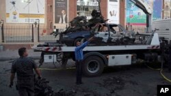 Iraqi security forces clean up a site in the aftermath of a bomb explosion near a shopping mall in eastern Baghdad, Iraq, Sept. 10, 2016.