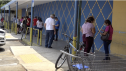 En los exteriores de los supermercados se forman largas filas de personas que quieren entrar. Las autoridades han obligado a sus residentes a mantener la distancia social en estos lugares.