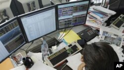 A broker speaks on the phone in a trading room in Paris, August 11, 2011