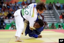 Slovenia's Tina Trstenjak, above, competes against France's Clarisse Agbegnenou, below, during the women's 61 kg judo gold medal match of the 2016 Summer Olympics in Rio de Janeiro, Brazil, Aug. 9, 2016.
