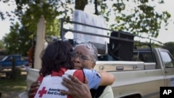 Joann Parks hugs Janice Sawyer as the Mississippi River's flooding waters rapidly near her home in Vicksburg.