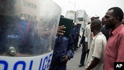 Opposition supporters and anti riot policemen face-off in front of the post office in Kinshasa, October 13, 2011.