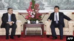 A Macau government handout picture shows Chinese President Xi Jinping (R) meeting with Macau Chief Executive Fernando Chui at the San Chok Un Guesthouse in Macau, Dec. 19, 2014. 