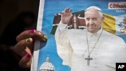 A churchgoer holds a copy of the Catholic Mirror newspaper showing a photograph of Pope Francis, after mass outside the Holy Family Minor Basilica in downtown Nairobi, Kenya, Nov. 22, 2015.