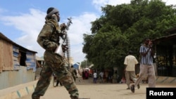 FILE - A Somali soldier patrols a street following a suicide car bomb and gun attack in Afgoye, Somalia, Oct. 19, 2016. 