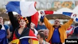 Fans watch French and German soccer teams’ quarterfinal match in the border town of Kehyl, Germany, near Strasbourg, July 4, 2014.