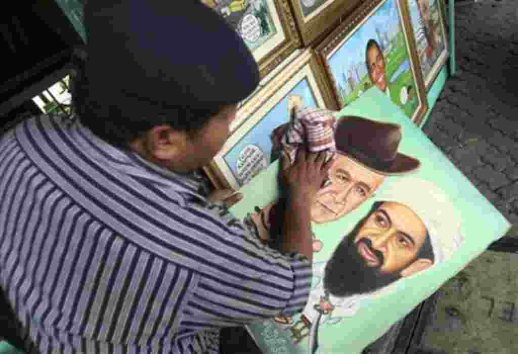 El pintor S. Wito, de Indonesia, seca la pintura de Osama bin Laden y el ex presidente de EE.UU. George Bush en su estudio de la calle del lado en Yakarta, Indonesia.