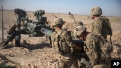 FILE - In a photo provided by Operation Resolute Support, U.S. Soldiers with Task Force Iron maneuver an M-777 howitzer, so it can be towed into position at Bost Airfield, Afghanistan.