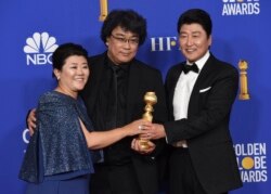 Lee Jeong-eun, from left, director Bong Joon-ho and Kang-Ho Song, from the cast and crew of "Parasite," pose in the press room with the award for best foreign language motion picture at the 77th annual Golden Globe Awards.