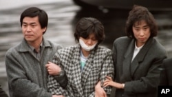 대한항공 여객기 폭파범인 북한 공장원 김현희가 1987년 12월 15일 김포공항으로 압송된 후 비행기에서 내리고 있다.