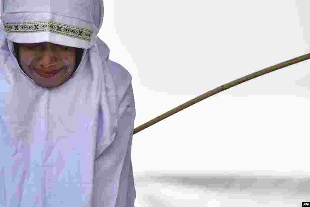 A woman is beaten in public in Banda Aceh in Indonesia&#39;s strongly conservative Aceh province as punishment for being too close to the opposite sex.