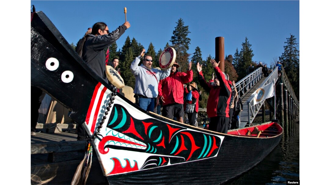 FILE - Members of the First Nation Tsleil-Waututh, Squamish and Musqueam bands sing during a protest of the Trans Mountain pipeline expansion in North Vancouver, British Columbia, Oct. 14, 2013.