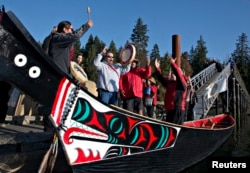 FILE - Members of the First Nation Tsleil-Waututh, Squamish and Musqueam bands sing during a protest of the Trans Mountain pipeline expansion in North Vancouver, British Columbia, Oct. 14, 2013.