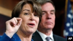 Sen. Amy Klobuchar, D-Minn., left, and Sen. Mark Warner, D-Va., speak about online political ads and preventing foreign interference in U.S. elections, during a news conference on Capitol Hill in Washington, Oct. 19, 2017. 