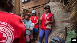 Red Cross volunteers talk to villagers about the plague outbreak, 30 miles west of Antananarivo, Madagascar, Oct. 16, 2017. 
