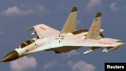 FILE - This Chinese J-11 fighter jet flew near a U.S. Navy P-8 Poseidon about 215 kilometers (135 miles) east of China's Hainan Island in this U.S. Department of Defense handout photo taken Aug. 19, 2014. 