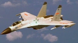 Chiến đấu cơ J-11 của Trung Quốc bay gần một máy bay trinh sát P8 Poseidon của Hoa Kỳ khoảng 215km (135 dặm) về phía đông đảo Hải Nam. (Ảnh tư liệu của Bộ Quốc phòng Mỹ ngày 19/8/2014). 