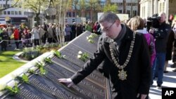 Walikota Belfast, Niall Ó Donnghaile, mengamati nama-nama korban yang meninggal dalam tragedi tenggelamnya kapal Titanic di tugu peringatan yang didirikan di Balai Kota Belfast, Irlandia Utara (15/4). Kapal mewah Titanic dibangun di kota ini dan tenggelam